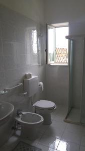 a bathroom with a toilet and a sink and a window at Villa Natalina in Ischia