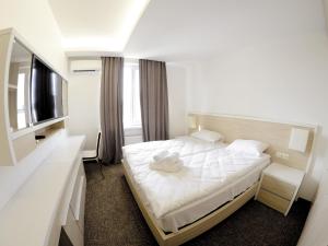 une chambre d'hôtel avec un lit et une télévision dans l'établissement Apartment OneClickRent 2 SmartHouse, à Chişinău