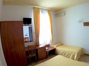 a bedroom with a desk and a bed and a window at Bed And Breakfast Perla Del Sole in Arenella