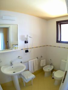 a white bathroom with a sink and a toilet at Bed And Breakfast Perla Del Sole in Arenella