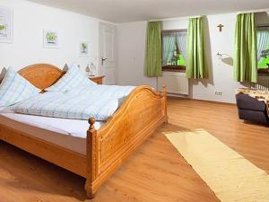 Schlafzimmer mit einem Holzbett mit grünen Vorhängen in der Unterkunft Gästehaus Pfnürlehen in Berchtesgaden