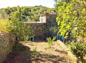 a stone house with a garden with trees in front of it at Lucrae' in Finale Ligure