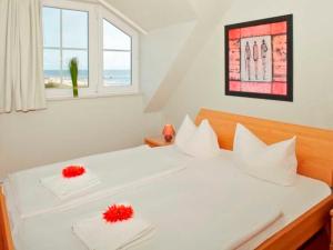 バンシンにあるDünen-Residenz A 20のベッドルーム1室(赤い花の白いベッド1台付)