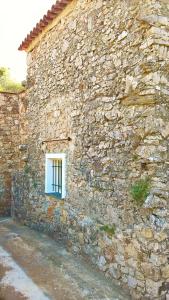 a window in the side of a stone building at Lucrae' in Finale Ligure