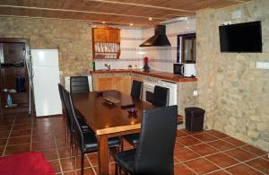 a dining room with a table and chairs and a kitchen at Casa Rural Los Cipreses in Benaoján