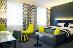 a hotel room with a bed and a couch at Vienna House by Wyndham Andel's Berlin in Berlin +115 photos