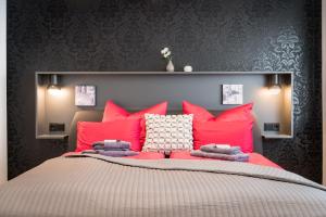 a bedroom with a large bed with pink pillows at Friedrich Boutique-Apartments in Freiburg im Breisgau