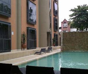 a swimming pool with two chairs in a building at The Wheatbaker in Lagos