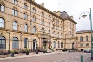 a large brick building with flags in front of it at Great Victoria Hotel in Bradford