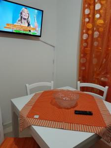 einen Tisch mit einer orangefarbenen Matte auf einem TV in der Unterkunft Alla casa di Anna in Trapani