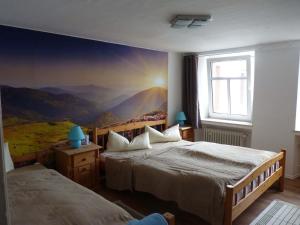 ein Schlafzimmer mit 2 Betten und einem Wandgemälde in der Unterkunft Eifel Ferienhaus Rodershausen in Rodershausen
