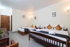 Un dormitorio con dos camas con toallas encima. en Chamraoen’s Home, en Siem Reap