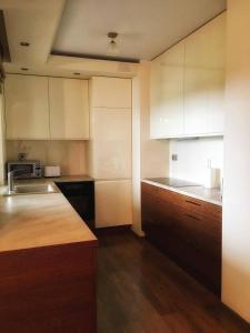 uma cozinha com armários brancos, um lavatório e um balcão em Apartament Vincent Metro em Varsóvia