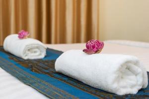 Dos toallas blancas con flores en una cama en Chamraoen’s Home, en Siem Reap