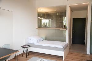a small bedroom with a bed and a mirror at Aiglberger Hofapartments in Steyr