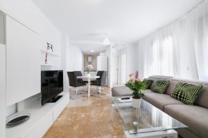 a living room with a couch and a table at Apartamentos Salamanca in M&aacute;laga