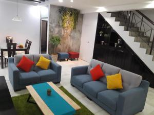 a living room with two couches and a staircase at Escape to Bukit Indah Legoland Retreat Your 5BR Homestay for 1-16 Guests in Johor Bahru