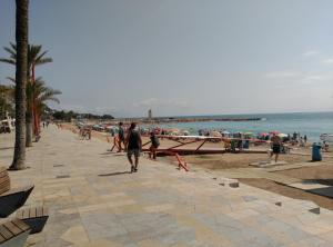 a group of people walking down a sidewalk near the beach at Nou Casablanca in Vinaròs