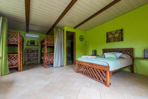 1 dormitorio con cama y pared verde en Cabanas Los Colibris en Copecito