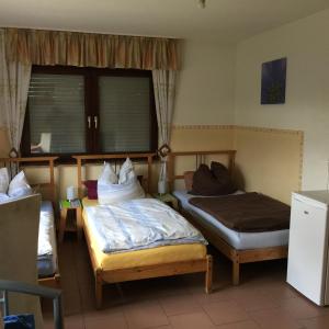 a bedroom with two beds and a window at Gästehaus Peterhoff in Düren - Eifel