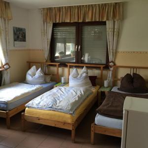 1 dormitorio con 2 camas y ventana en Gästehaus Peterhoff, en Düren - Eifel