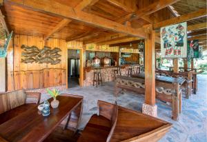 a dining room with wooden tables and chairs in a cabin at Dai Yuan Inn in Mengla