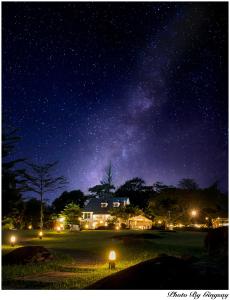 a starry night with a house and the milky way at The Natural Garden Resort in Ban Thap Sai