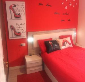 un dormitorio rojo con una cama con sábanas rojas y zapatos en la pared en Apartamento En Pleno Centro, en A Coruña