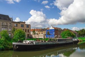 a large boat on a river in a city at B&B B³ Boat in Ghent