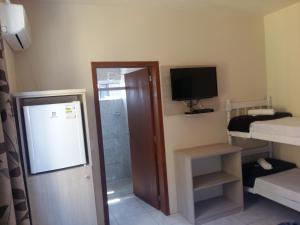 a small room with a room with a bed and a television at Hotel Rochamar in Penha