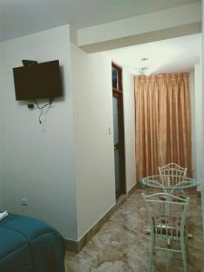 a room with a tv on the wall and a table and chairs at Hotel Elizabeth Hoss in Sayán +26 photos