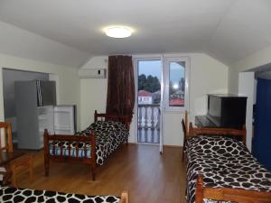 a living room with two beds and a window at Festina Lente in Kobuleti