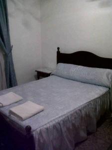 a bedroom with a bed with two towels on it at Hostal Medina in Olvera