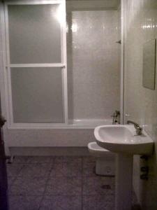 La salle de bains est pourvue de toilettes, d'un lavabo et d'une douche. dans l'établissement Hostal Medina, à Olvera