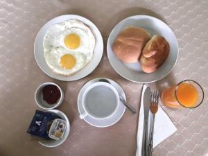 a table topped with two plates of eggs and bread at Hostal Solari in Trujillo