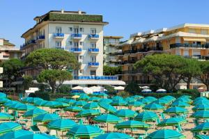 eine große Gruppe blauer Sonnenschirme am Strand in der Unterkunft Hotel Croce Di Malta in Lido di Jesolo