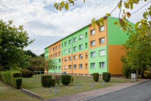 a brightly colored building with chairs in front of it at Komfort Ferienwohnungen Zwenkauer See in Zwenkau