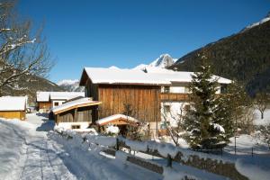 ein schneebedecktes Haus mit einem Zaun in der Unterkunft Ferienhaus Wechner in Häselgehr