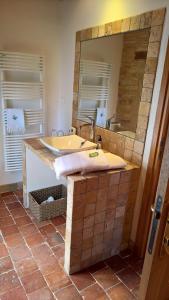 uma casa de banho com uma banheira e um espelho grande em Le Clos des Pierres Dorées em Theizé