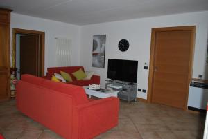 カヴァイオーン・ヴェロネーゼにあるAppartpaolaのリビングルーム(赤いソファ、テレビ付)