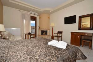 a hotel room with a bed and a fireplace at Hotel Philippion in Kato Loutraki