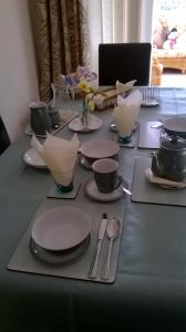 a table with plates and utensils and a laptop at Bridge End in Northallerton