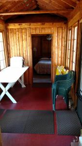 um quarto com uma cadeira verde numa cabina em Log Cottage on Blue Lake em Kalkaska