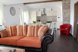 a living room with a couch and a kitchen at BodenSEE Apartment Steinackerweg in Meckenbeuren