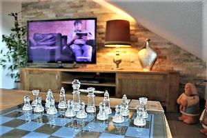 BodenSEE Apartment Steinackerweg في ميكنبورن: لوحة شطرنج على طاولة أمام التلفزيون
