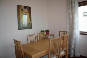 mesa de comedor con sillas y una foto en la pared en Apartamento em frente ao Mar, en Vila do Conde