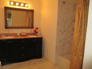 
a bathroom with a mirror, sink, and toilet at Ocean West Boutique Hotel in Nassau
