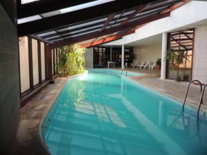 an indoor swimming pool with blue water in a building at Complejo Marges in Villa Gesell