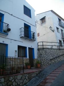 un edificio blanco con ventanas azules y una valla en Casa La Chelva, en Alcudia de Veo
