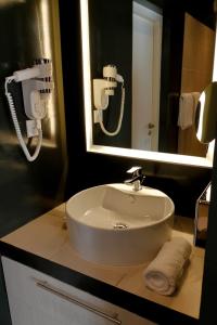 a white sink in a bathroom with a mirror at ONOMO Hotel Lomé in Lomé